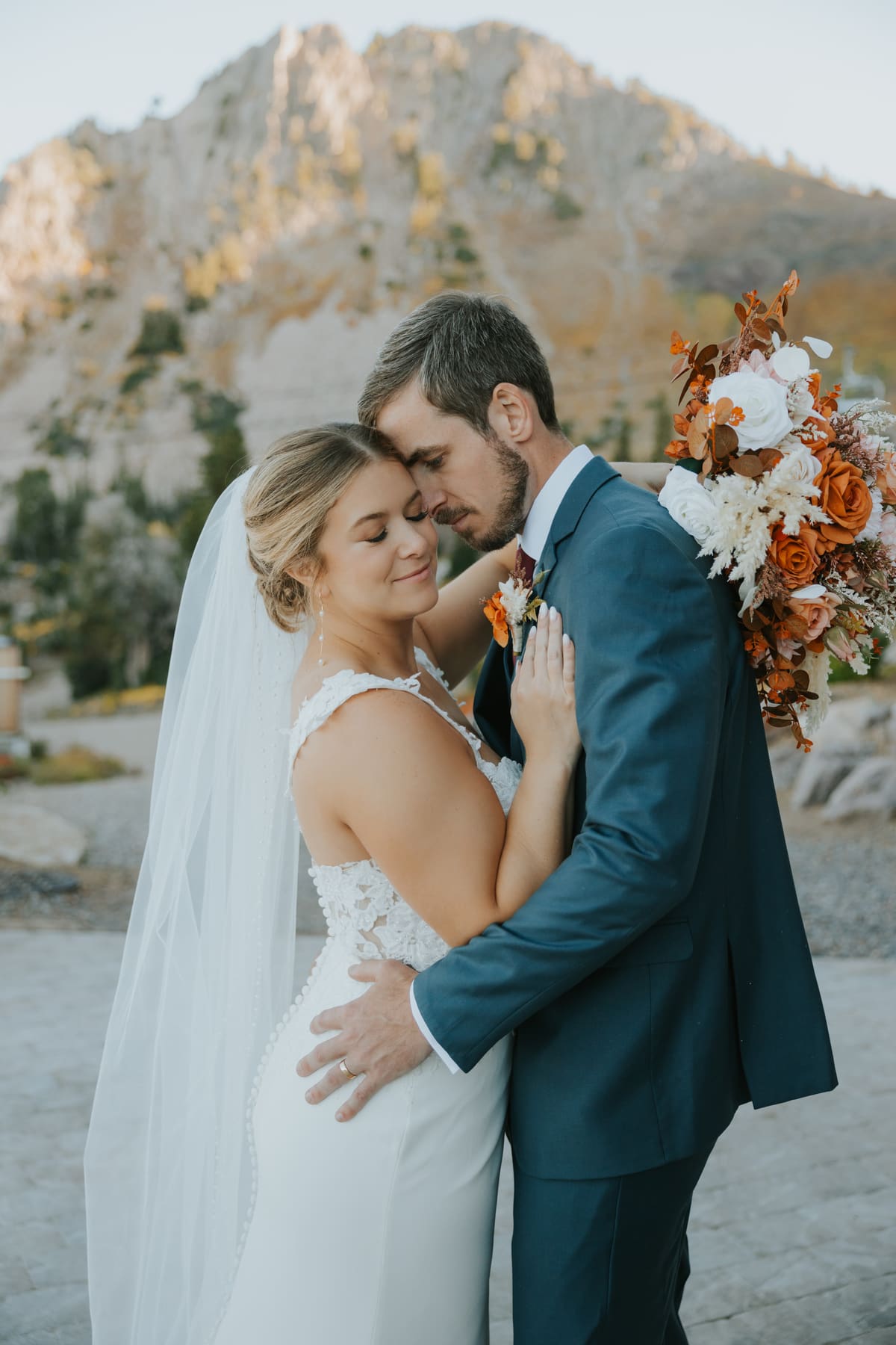 A newly married couple embracing in the Utah mountains